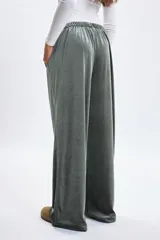 Pantalón de corte ancho confeccionado en tela de plush con acabado satinado. Presenta cintura elástica con cordón de ajuste y bolsillos laterales.
