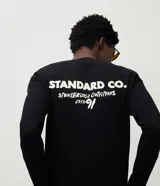 Remera de manga larga confeccionada en tejido de algodón con textura tipo waffle. Presenta un diseño de calce regular con estampado tipográfico en la espalda y cuello redondo.