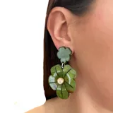 Aros colgantes con forma de flor hechos de resina color verde. Se ajustan con perforación y no contienen níquel.