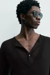 Jersey negro de punto fino, con cuello pico profundo y mangas largas. Terminaciones acanaladas.