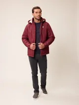 Campera de nylon gris con capucha, cierre frontal completo y bolsillos laterales. Presenta un diseño minimalista con logo bordado en el pecho.