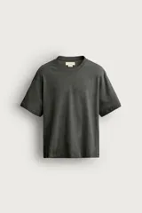 Camiseta de corte relaxed fit, confeccionada en mezcla de algodón y lino, con cuello redondo y mangas cortas.