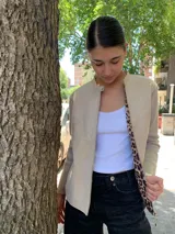 Campera color beige con mangas largas de tejido de punto y cuerpo de cuero sintético. Interior con estampado animal print.