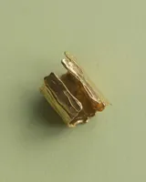 Anillo dorado con textura irregular que imita la rusticidad del tiempo.