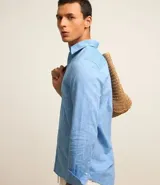 Camisa comfort masculina de lino y algodón color celeste, con cuello inglés, manga larga y abotonado delantero.