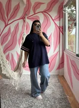 Remerón oversize azul marino de algodón con mangas cortas y tres tiras rosas en los hombros.