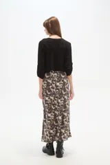 Falda larga de corte recto con abertura lateral pronunciada, confeccionada en tejido fluido con estampado abstracto en tonos tierra y crema.