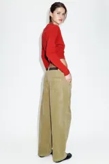 Pantalón de tiro alto confeccionado en pana, con diseño de pernera holgada que se estrecha hacia el tobillo. Presenta bolsillos delanteros, bolsillos de plastrón en la parte trasera, costuras marcadas en el frente y cierre frontal con cremallera y botón.