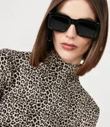 Blusa de manga larga ajustada al cuerpo con cuello alto y estampado de leopardo en tonos beige y negro.
