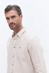Camisa de manga larga confeccionada en viyela de algodón, con cierre frontal de botones y bolsillo en el pecho. Presenta un diseño clásico de calce cómodo y textura suave.