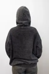 Canguro con capucha de calce holgado, confeccionado en tejido con efecto lavado ácido en color gris oscuro. Presenta un bordado tonal en el centro del pecho y un bolsillo frontal tipo canguro.