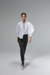 Pantalón negro de cuero de oveja, corte recto, tiro medio, cierre lateral plateado, forro interno con stretch y tajos en el dobladillo.