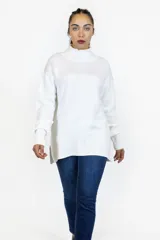Buzo de punto color blanco, con cuello alto, mangas largas con puños acanalados y diseño recto con aberturas laterales en el ruedo.