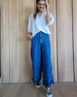 Pantalón de jean azul de corte palazzo con cintura alta y detalle de costuras horizontales en el ruedo.