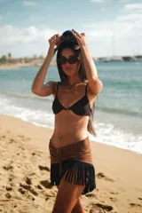 Top de bikini con aro y estribo metálico en el centro, de color negro con detalles marrón oscuro.