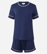 Conjunto de pijama compuesto por una remera de manga corta y un short, ambos confeccionados en viscolycra azul marino con detalles de ribetes en color blanco en cuello, mangas y ruedo del short. El short cuenta con cintura elástica.