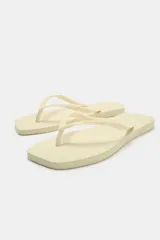 Sandalias planas de dedo tipo ojota, color negro, con diseño minimalista y suela de goma con textura en relieve.