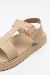 Sandalia baja negra con tiras anchas y hebilla lateral.