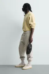 Riñonera negra de tejido técnico con múltiples compartimentos con cierre de cremallera, incluyendo uno frontal y uno interior. Posee asa ajustable con hebilla metálica de liberación rápida.