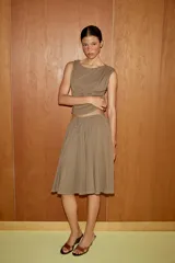 Falda midi de corte acampanado, confeccionada en tejido de algodón con textura flamé. Presenta cintura elástica con cordón ajustable y diseño fluido con godets.