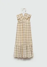 Vestido largo de algodón con estampado de cuadros oscuros sobre fondo beige. Presenta diseño evasé, cuello halter con tirantes finos y detalle de panel nido de abeja en la parte superior.