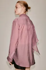 Camisa de manga larga confeccionada en mezcla de lyocell, con cuello fluido tipo pañuelo integrado, cierre frontal con botones ocultos por solapa y bajo redondeado asimétrico.