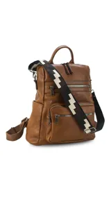 Mochila de símil cuero color marrón con apertura superior y tres bolsillos frontales con cierres metálicos. Cuenta con bolsillos laterales y una correa de galón con diseño geométrico, regulable y extraíble, que permite su uso como bandolera.