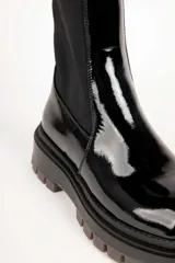 Bota baja de mujer estilo paddock, color negro, con suela track gruesa y caña de tejido elástico.