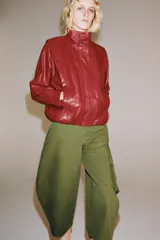 Jeans capri de tiro medio y corte balloon leg en color verde militar. Presenta trabillas en la cintura, bolsillos laterales y bolsillos de plastrón tipo cargo en las piernas. Cuenta con cierre frontal con cremallera y botón metálico.