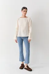 Jean de corte cropped y tiro alto, color azul oscuro, con diseño de pierna ligeramente acampanada y ruedo deshilachado.