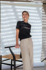 Pantalón de corte sastrero con cintura alta, pinzas delanteras y pierna ancha de caída fluida.