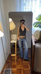 Top negro con escote halter y espalda descubierta con tiras ajustables.