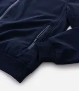 Campera tipo bomber color beige, con cierre frontal de cremallera, cuello estilo béisbol, puños y ruedo acanalados. Cuenta con bolsillos laterales con cierre y tecnología repelente al agua.