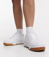 Championes blancos de caña baja con recortes, lazo por cordón y suela contrastante color marrón.