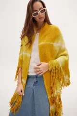 Chaleco tipo poncho tejido a crochet con diseño tie-dye en tonos amarillo y blanco, con flecos en el ruedo.
