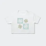 Remera corta blanca con estampado de flores geométricas en tonos verde y celeste.