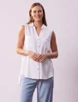 Blusa blanca sin mangas de lino, marca Zac & Rachel. Cuello con solapa, escote en V y abertura central con botones. Delantera con bolsillos aplicados. Laterales con botones aplicados.