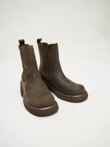 Bota tipo chelsea de cuero vacuno en color rojo con estampado floral grabado en negro. Presenta paneles laterales elásticos, suela de plataforma y taco cuadrado en color negro.