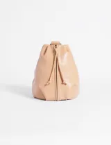 Riñonera color beige de cuero sintético, con cierre vertical y correa regulable para usar cruzada.