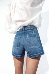 Short de denim azul de tiro alto, confeccionado en algodón levemente elástico con bolsillos delanteros de parche.