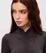 Body de manga larga con cuello alto y detalle de fruncido central en el frente. Confeccionado en tejido seamless ajustado al cuerpo.