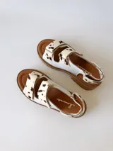 Sandalias con plataforma color marrón y tiras de cuero sintético con estampado animal print de vaca.