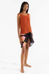 Pareo negro con estampado de flores abstractas en tonos fucsia y naranja.