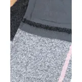 Bufanda rectangular de tejido grueso con diseño de cuadros en tonos azul, naranja, gris y beige, terminada con flecos en los extremos.