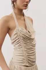 Top negro con diseño cruzado tipo halter, escote pronunciado y fruncido lateral.
