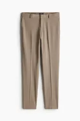 Pantalón de vestir color beige, corte slim fit, con cierre y corchete oculto, bolsillos laterales y bolsillos ribeteados con botón atrás.