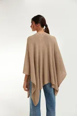 Ruana de tejido punto en color beige, con diseño amplio y caida fluida.
