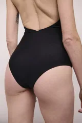 Malla enteriza negra con escote halter y paneles de tul transparente en la zona del abdomen y laterales.