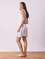 Camisón corto negro con estampado de lunares blancos, escote en V con botones y detalle plisado en el pecho.