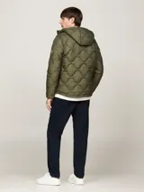 Campera acolchada verde militar con capucha fija y cordón ajustable, cierre de cremallera, dos bolsillos diagonales en la cintura y parche con el logo de Tommy Hilfiger en la manga. Repele el agua y cuenta con aislamiento térmico.